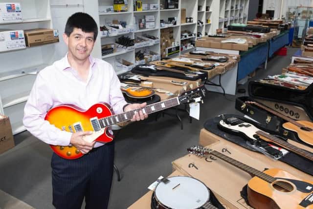 Auctioneer Paul Cooper and some of the thousands of pounds worth of guitars up for auction.