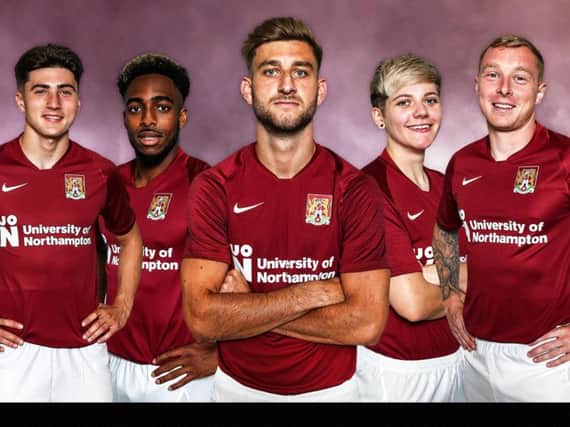 The new Cobblers home kit for season 2019/20 is modelled by (from left) Scott Pollock, new signing Reece Hall-Johnson, team captain Charlie Goode, Alex Bartlett from Northampton Town Ladies and club captain Nicky Adams