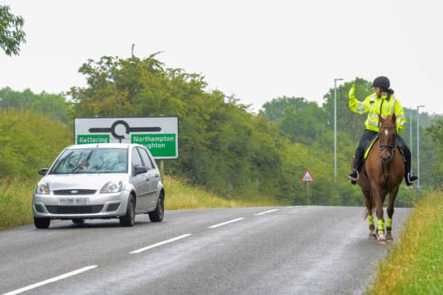 A Northamptonshire Police volunteers on horseback rider waves past a more considerate driver during the Operation Close Pass test