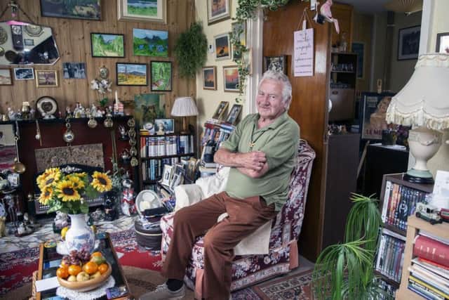 Tony Mallard sits telling stories in his Eastfield living room surrounded by his original artwork.