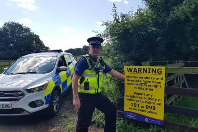 PCSO Les Conopo with the warning signs put up across Northamptonshire as a result of the sheep attacks. Photo: Northamptonshire Police