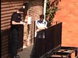 A police officer talks to Jamie Ridley outside his flat after the incident
