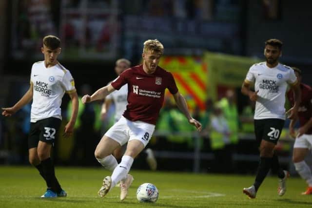Ryan Watson on the ball for the Cobblers against Posh. He would later go off injured
