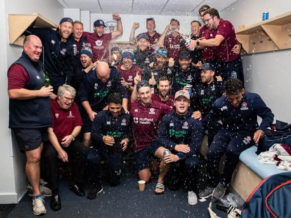 The Northants players and staff celebrate promotion at Bristol on Thursday morning