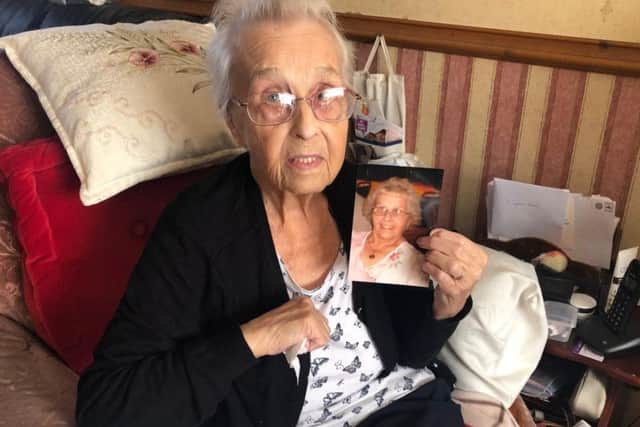 Eighty-four-year-old Joyce is pictured holding up a photo of her wearing the necklace she's searching for.