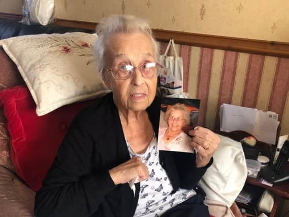 Eighty-four-year-old Joyce is pictured holding up a photo of her wearing the necklace she's searching for.