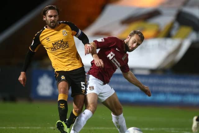 Andy Williams fights for the ball during the Cobblers' win at Cambridge
