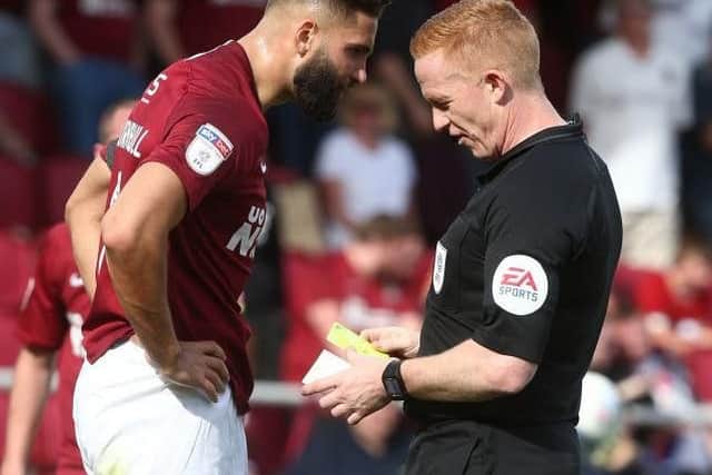 In trouble: Jordan Turnbull is booked by Alan Young during Cobblers' win over Newport last month.