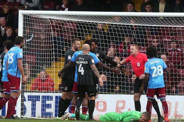 Scunthorpe's players reacted angrily after goalkeeper Rory Watson was caught in the face by Vadaine Oliver. Picture: Pete Norton