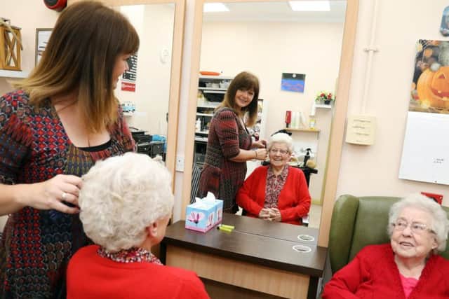 Hairdresser Gillian Lamb puts the finishing touches to Margaret Sykes, watched by Tess Porter.