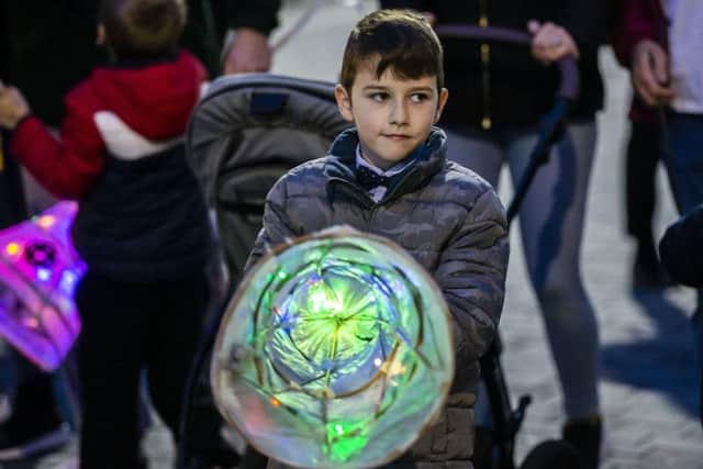 The procession is joined by hundreds of residents and children carrying lights and lanterns.