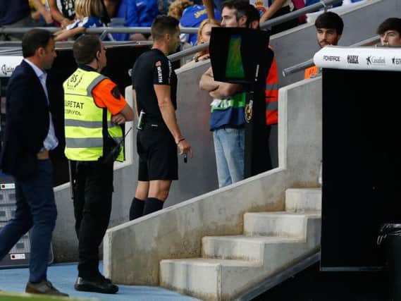 How it should be... referee Del Cerro Grande checks a decision on the pitch side monitor during Sunday's Espanyol versus Villarreal clash in La Liga