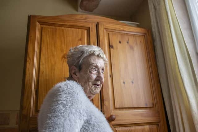 Rita stood next to her wardrobe which has bowels on top to catch rainfall. Pictures by Kirsty Edmonds.