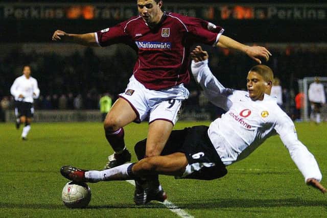 Marc Richards is tackled by Manchester United's Wes Brown during the FA Cup fourth round clash at Sixfields in January, 2004