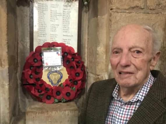 Albert 'Ted' Collins next to the memorial in Church Bampton, where his name appears on the roll of honour for his service in WW2