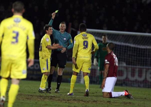 YELLOW PERIL - Darren Sheldrake books Torquay's Elliot Benyon at Sixfields, one of six yellow cards he dished out (Picture: Kelly Cooper)