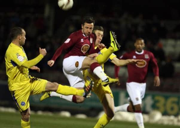 HIGH KICKING - Cobblers striker Roy O'Donovan is denied by the Torquay defenders (Picture: Kelly Cooper)