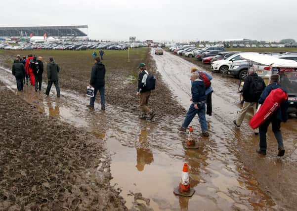 Spectators make their way through the mud as they arrive for the British Grand Prix.
