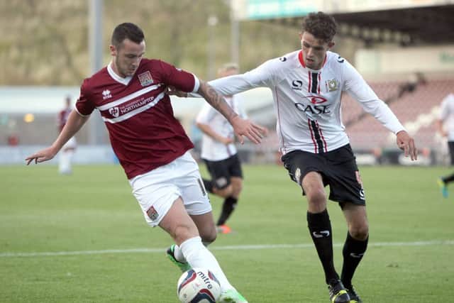 Cobblers striker Roy O'Donovan battles it out with MK Dons' Tom Flanagan (pictures: Tony Waugh)