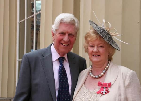 Sally Smith pictured with her husband, Graham, in the Palace Courtyard after receiving her MBE
