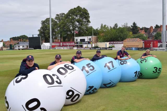 Northamptonshire Steelbacks pose with giant lottery balls in a bid to trace a missing £2.6 million jackpot winner in the county.