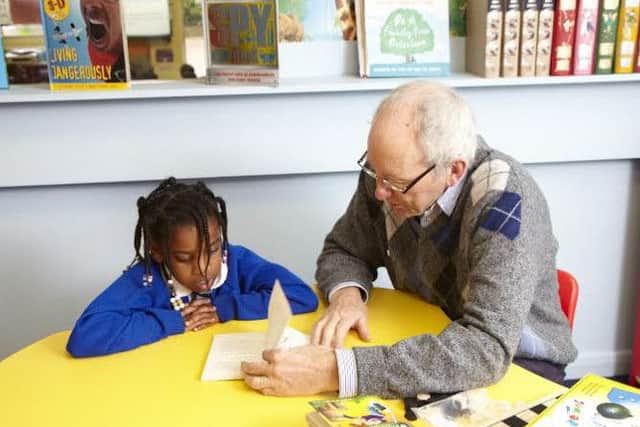 A Beanstalk volunteer helps a child with their literacy