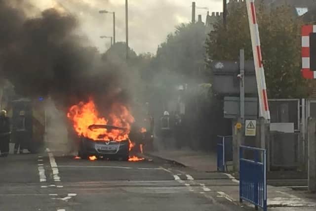Firefighters extinguish a Vauxhall Zafira which caught light. PHOTO: PRESS ASSOCIATION