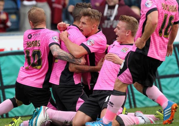 IN THE PINK - the Cobblers players mob Marc Richards after his free-kick strike at Wycombe
