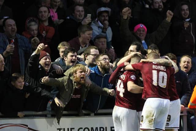 Northampton Town players and fans celebrating after Ricky Holmes' second goal in the original match.
