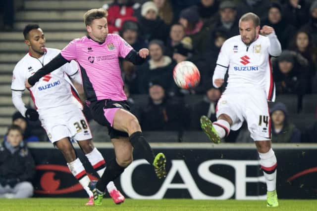 GETTING STUCK IN - Joel Byrom challenges MK Dons midfielder Samir Carruthers (Pictures: Kirsty Edmonds)