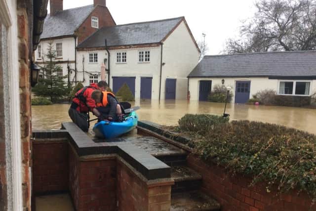 Dr Wyse and daughter Lara, setting off from their home in the kayak. Underneath the torrent of water in the picture is a swimming pool.