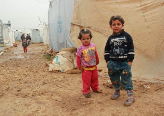 Picture shows refugee children in a temporary camp, courtesy of Children on the Edge