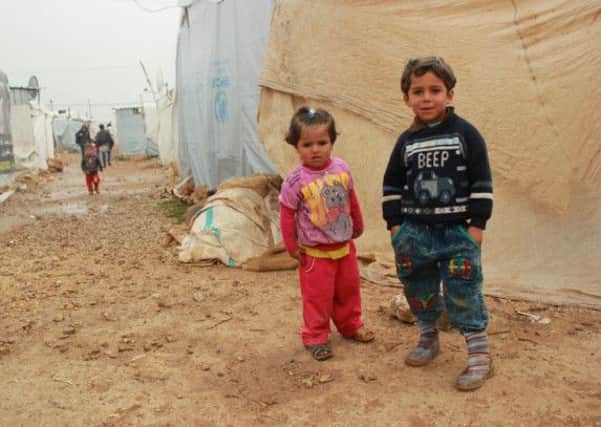 Picture shows refugee children in a temporary camp, courtesy of Children on the Edge