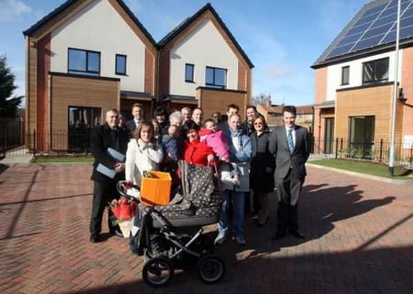 Families gather outside some of the town's newset council homes built in Woodside Way, Kings Heath. February 2011.