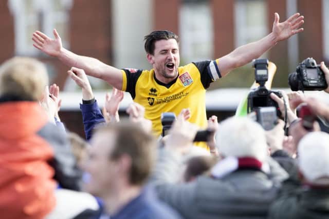 RIDING HIGH! - Dave Buchanan celebrates with the Cobblers fans after clinching the title at Exeter City (Pictures: Kirsty Edmonds)