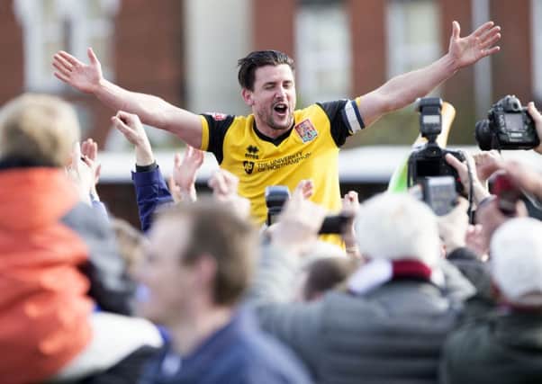 RIDING HIGH! - Dave Buchanan celebrates with the Cobblers fans after clinching the title at Exeter City (Pictures: Kirsty Edmonds)