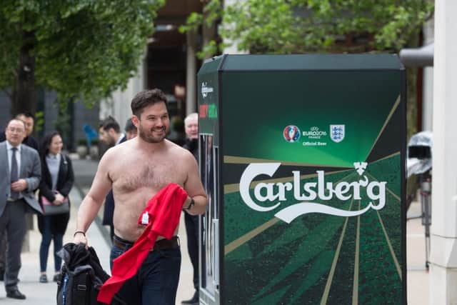 An office worker substitutes his work shirt for an England shirt during a previous stunt at Sheldon Square in London. David Parry/PA Wire