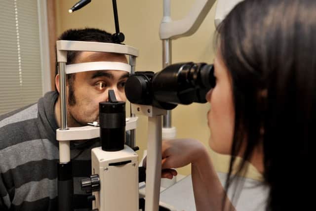 Simon Hull is grateful to Specsavers who helped diagnose a tumor behind his left eye after had problems with his vision. Pictured with optician Rebecca Mazzarella. ENGEMN00120111203134237