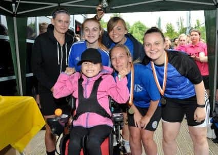 Faye Baggaley, the 100th recipient to receive a customised powered wheelchair presents Northamptons ladies team with their medals