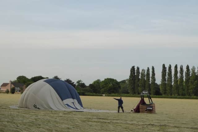 Hot air balloon on a field of hay. Picture copyright Heather Jan Brunt