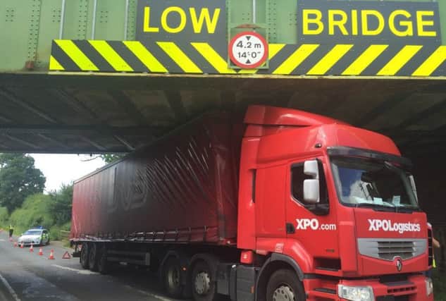 A lorry has beome stuck under a railway bridge between East Haddon and Harlestone.