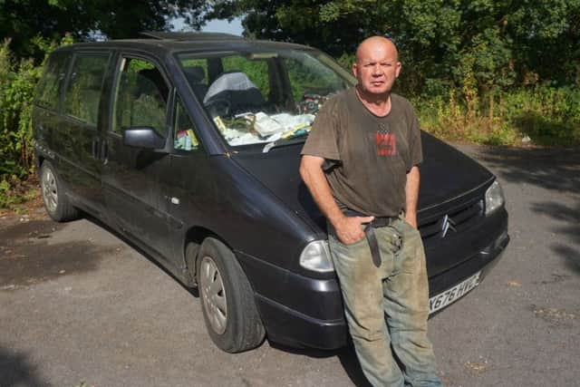 David Reeve next to the car he and his wife live in.