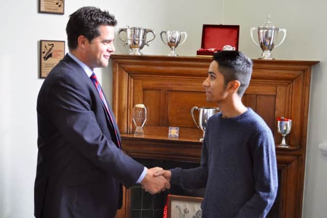 Emad Abdullah receives a handshake off the headmaster, Richard Bernard.
