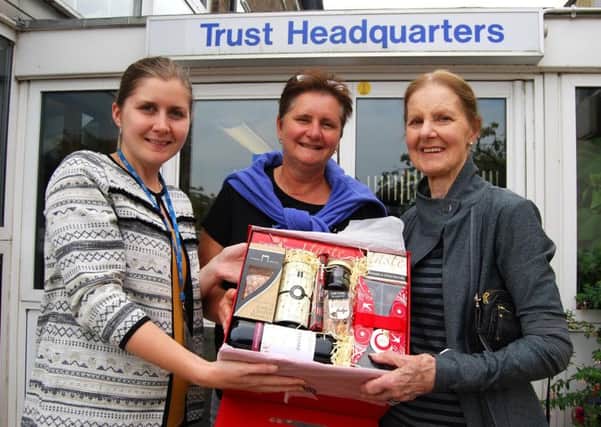 Diana Green, right, receives a hamper as a thank you from KGH Charity Officer Christina Kelly after making the largest single donation to the KGH Charity Fund following a 400ft abseil event in June. Her daughter Sue Gates is in the middle