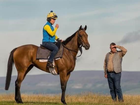 Becky Smith sporting her habitual yellow riding helmet on board Angel Meadow on the Middleham gallops with trainer Micky Hammond