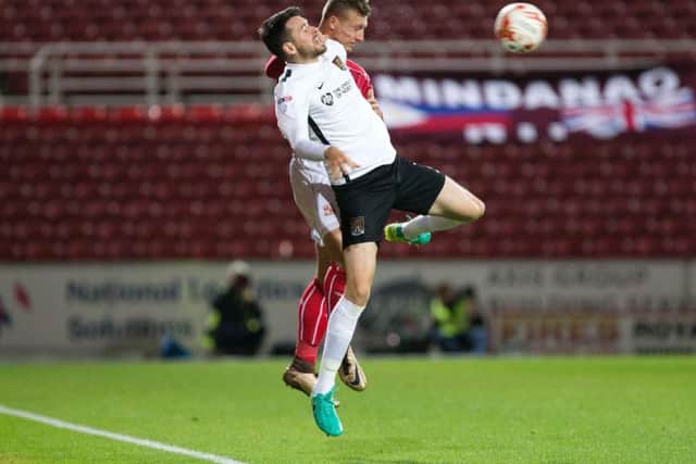 Brendan Moloney challenges for the ball at Swindon