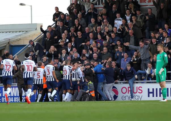 GIFT-WRAPPED THREE POINTS - the Millwall players and supporters celebrate their second goal in Saturday's 3-1 win at Sixfields (Picture: Sharon Lucey)