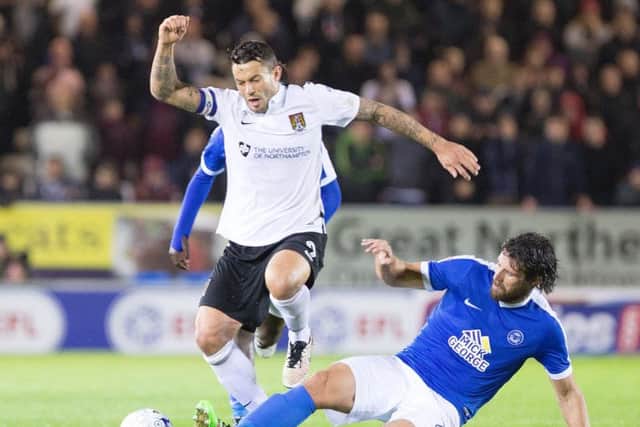 Marc Richards is tackled by Peterborough United's Michael Bostwick