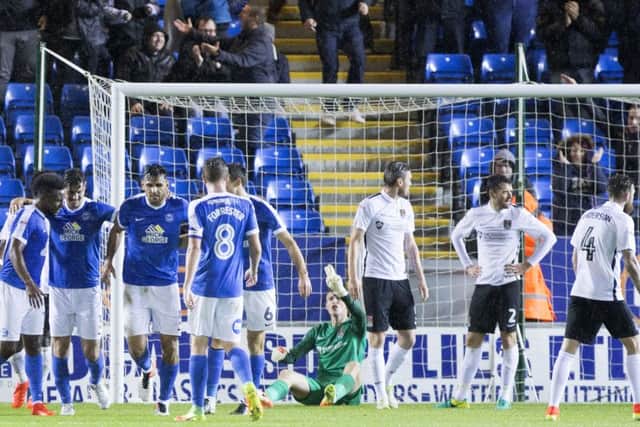 PAINFUL EXPERIENCE - Peterborough's players celebrate their second goal in Tuesday's derby, while the inquest begins for the Cobblers defence (Picture: Kirsty Edmonds)