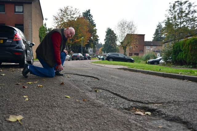 Mr Gordon looks over some of the pothole-riddled roads, long overdue a resurface.